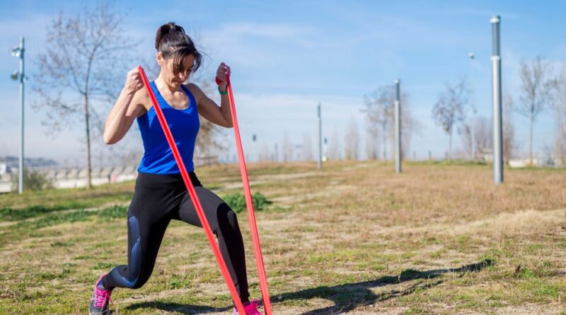 a female athlete training with a resistance team on a grass field